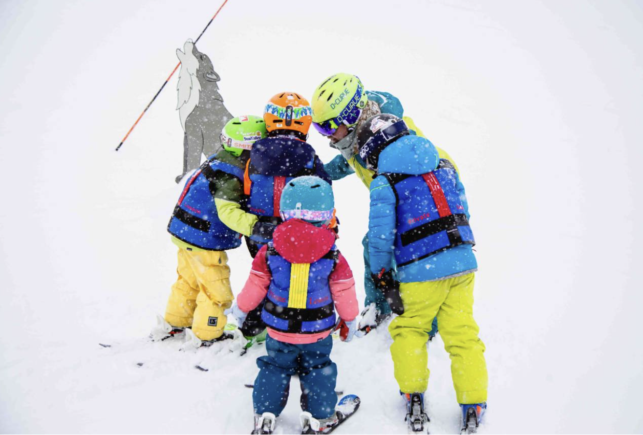 An instructor kneeling to talk with children